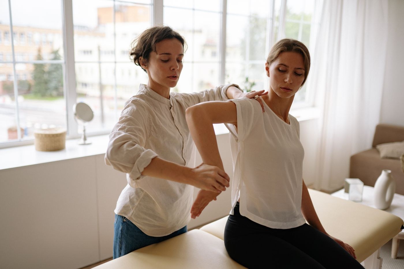 Stock photo of a therapist guiding a patient's shoulder rehabilitation